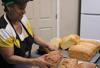 Spouses Bakery and Deli owner Vanessa Logan shows off loaves of sourdough bread.