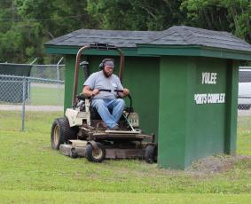 Nassau County’s Shaun Maguire mows grass at the Yulee Sports Complex on Thursday morning.