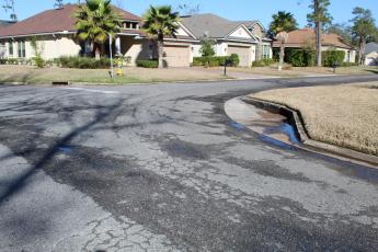 On a sunny, dry day, there is water seeping out of the pavement on Spanish Way in the Isle de Mai subdivision. The city of Fernandina Beach filed a lawsuit against CPH Engineering, claiming the company built the road too low, causing water to damage the street. CPH offered the city $80,000 in cash and in-kind services to settle the matter, which the City Commission rejected.