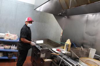 Jose Hernandez works the grill at Pepper’s Cocina Mexicana on Centre Street. The restaurant is working with a smaller staff, as are many across the state, making for longer waits, closed sections and even shorter of hours of operation for some establishments.