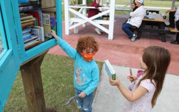 Olive Johnakin, 4, left, and Amelia Pipkin, 4, check out the available books from the Little Free Library at Central Park in Fernandina Beach. SCOTT J. BRYAN/NEWS-LEADER