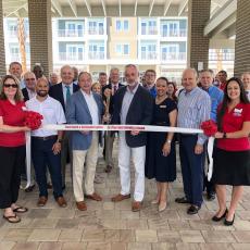 A major project came to fruition Tuesday with a ribbon cutting to celebrate the opening of two Marriott hotels on Atlantic Avenue. Holding the scissors in the middle of the photo is primary owner Greg Grove and Jason Nicholason, vice president of hotel operations at Innisfree Hotels.