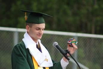 Valedictorian Haden Cottrell holds up a Rubik’s cube to describe students’ future challenges in college.