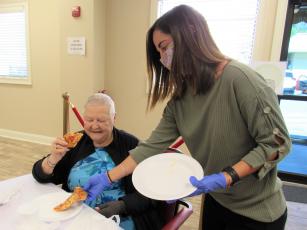 Nassau County Council on Aging’s dietician, Madeline Donovan, serves pizza to Gail Wagner.