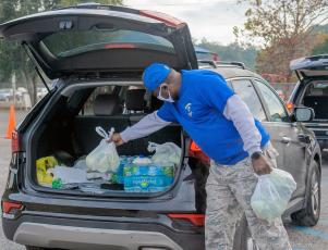 A volunteer places groceries into a vehicle at a recent food distribution. The drive-thru events are held throughout Nassau. 