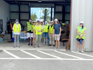 Keep Nassau Beautiful staff and volunteers gather in the shade. They collected hazardous waste from 538 residents Aug. 15. The residents who participated also donated a total of half a ton of non-perishable food items for the Barnabas Food Pantry. 