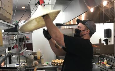 Josh Sheppard has worked for Coastal Pizza for just under four years, coming with the company from Yulee to their new Amelia Island location. Twirling pizza dough into the air, he said he has fun at work, adding, “I love what I do.” JULIA ROBERTS/NEWS-LEADER