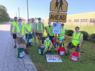 Boy Scouts and leaders from Callahan Boy Scout Troop 351 wear safety vests, gloves and masks for their first Adopt-a-Road clean-up event. They collected more than 175 pounds of litter and debris during their first clean-up event. 