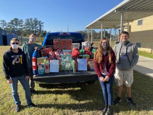Air Force JROTC cadets display some of the toys they donated to Callahan Volunteer Fire Department’s annual giveaway. The station’s volunteers delivered the toys to children as they drove Santa and his elves through town.