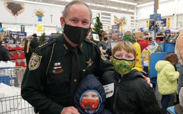 Nassau County Sheriff Bill Leeper and law enforcement officials from the area helped more than 300 Nassau County children Christmas shop at the Yulee Walmart earlier this month. SUBMITTED PHOTO