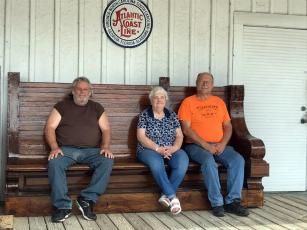 West Nassau Historical Society members Jerry Peterson, from left, Emily Baumgartner and John Hendricks take a break at the Callahan Depot on one of two restored benches that were once part of the Jacksonville Union Terminal waiting area in 1919. Dorothy Higginbotham donated the benches. 