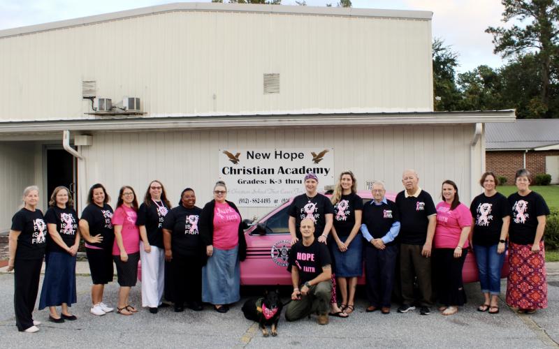 Natalie Furr (center) is facing a second diagnosis of breast cancer this year with support from her husband, county deputy Jerry Furr, his K-9 partner Bella and her coworkers at New Hope Christian Academy. 