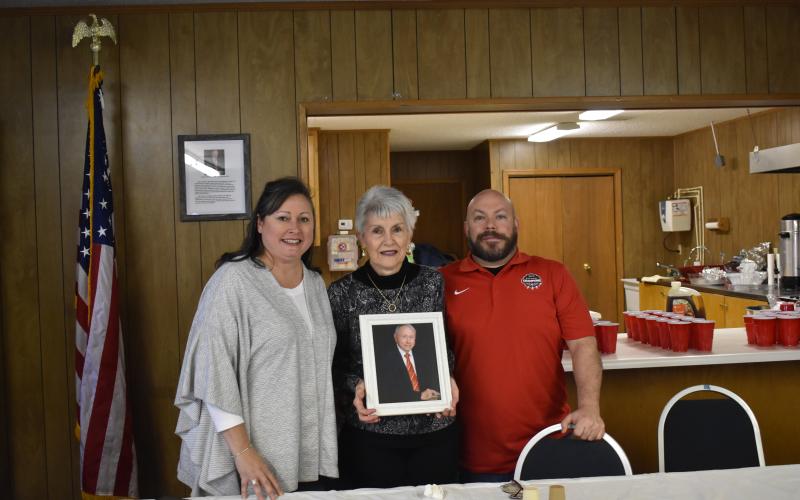 Suzanne M. Johnson, Mary McCollum and Butch Livingstone hold up a photo of Jimmy McCollum, for whom the American Legion Post 170 was named after during a ceremony Saturday.