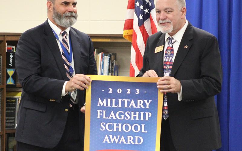 Camden Middle School Principal Heath Heron, left, accepts the Military Flagship School Award banner from Georgia State Superintendent Richard Woods.