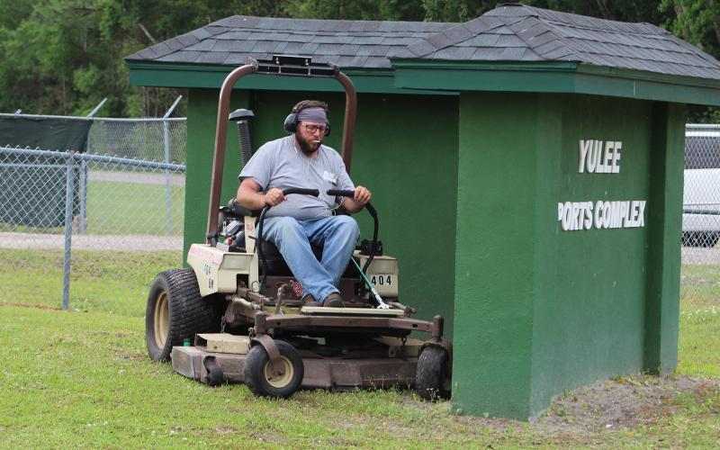 Nassau County’s Shaun Maguire mows grass at the Yulee Sports Complex on Thursday morning.