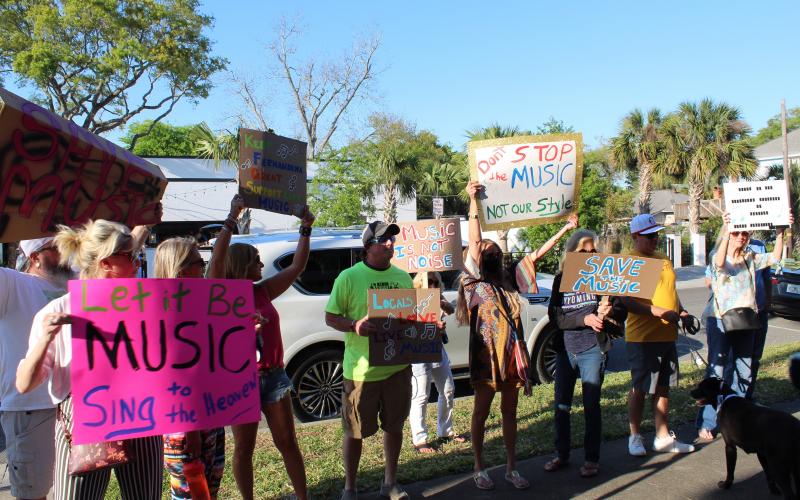 People stand outside Fernandina Beach City Hall in support of live music downtown. City commissioners passed first reading of a law they hope will allow music to be performed while avoiding disturbing downtown residents.