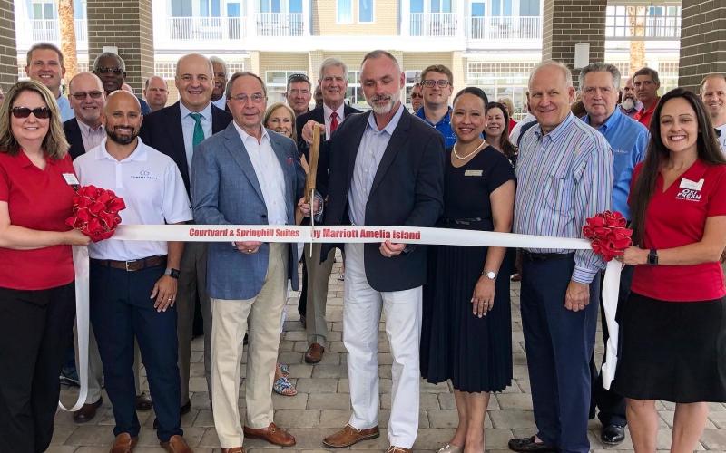 A major project came to fruition Tuesday with a ribbon cutting to celebrate the opening of two Marriott hotels on Atlantic Avenue. Holding the scissors in the middle of the photo is primary owner Greg Grove and Jason Nicholason, vice president of hotel operations at Innisfree Hotels.