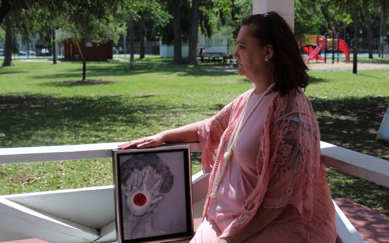 Leighanne Bohrer was a victim of sexual assault, and through the Women’s Center of Jacksonville, she’s received counseling, support and help when dealing with law enforcement officials concerning her allegations. She’s pictured with a piece of artwork from Barbara Kiersh.