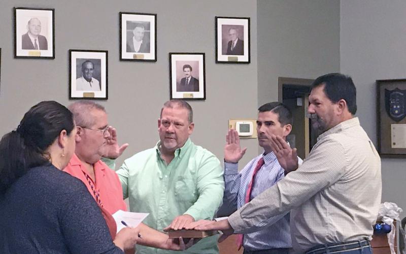 Hilliard town councilmen Kenny Sims, Jared Wollitz and Lee Pickett take the oath of office as Town Clerk Lisa Purvis officiates while Council President John Beasley holds a Bible.
