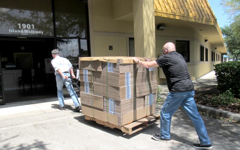 Nassau County Council on Aging Transportation Director Mike Hays and volunteer Philip Chapman roll a pallet of WestRock-donated boxes into the Fernandina Beach Life Center.