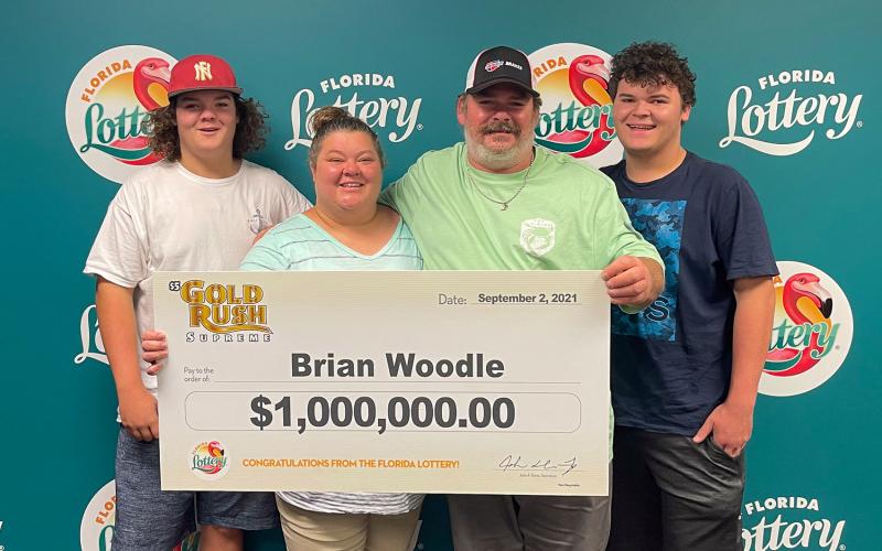 Brian Woodle poses for a photo with his family after winning $880,000 from the Florida Lottery with a Gold Rush Supreme scratch-off ticket.