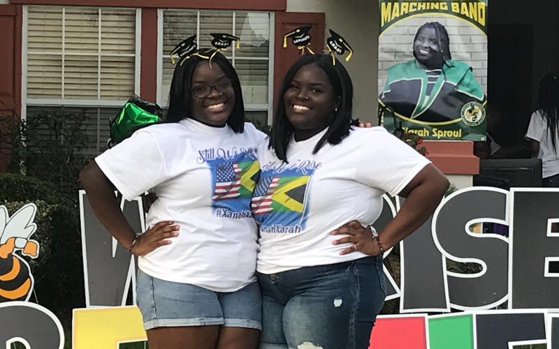 Xanah and Xarah Sproul say they haven’t let racist comments made in an anonymous letter ruin their high school graduation experience. “And still I rise,” a quote from Maya Angelou, decorated their lawn during a parade of supporters driving past their house. JULIA ROBERTS/NEWS-LEADER