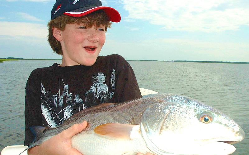 Caleb Goyette is all smiles after catching this big Amelia Island redfish. TERRY LACOSS/SPECIAL