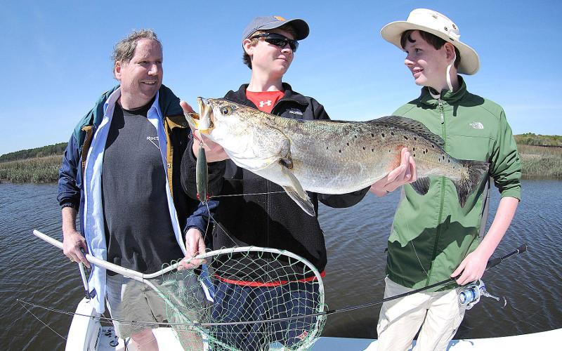 George Holstrom, Josh Holstrom and Will Blankenship, from left, are pictured with a giant Amelia Island sea trout caught with a minnow-type plug. TERRY LACOSS/SPECIAL